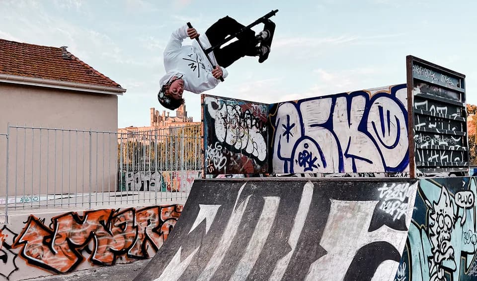 Camille Scooters en figure inversée sur un skatepark